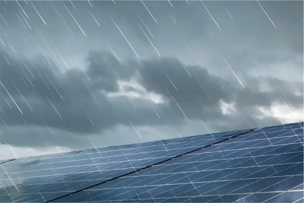 Rain falling on solar panels under a cloudy sky, showing solar energy performance in rainy weather.